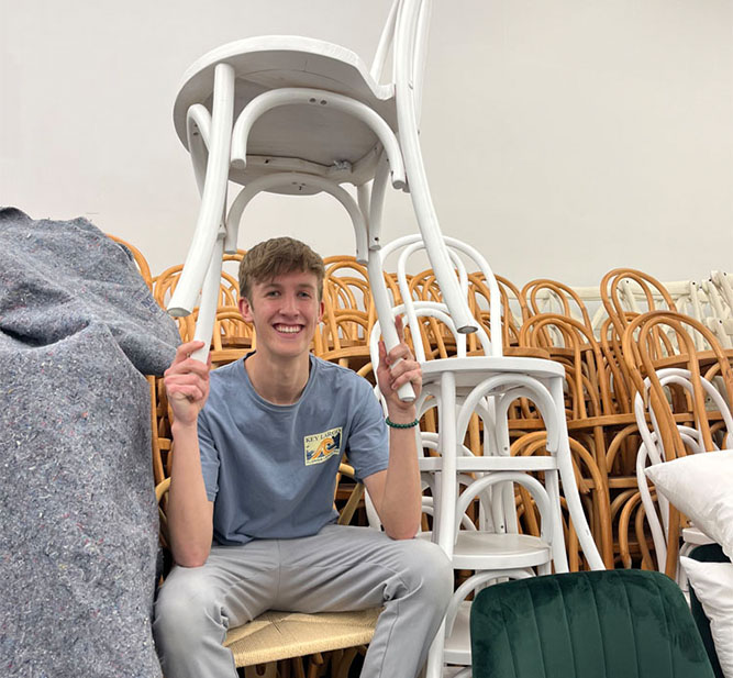 Sam holding a chair above his head
